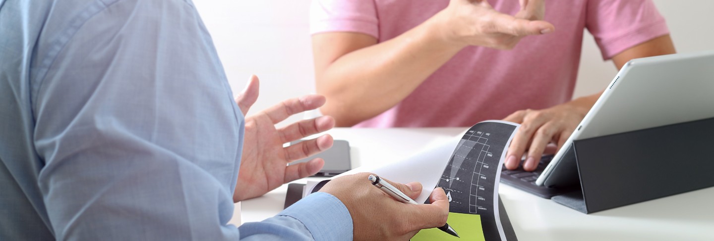 Businessmen working together on a document and using smartphone
