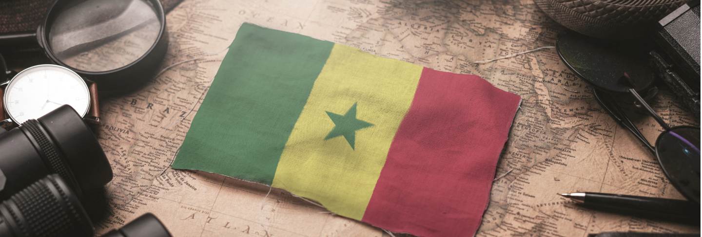 Senegal flag between traveler's accessories on old vintage map. tourist destination concept.