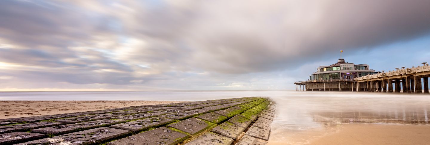 The palace pier at blankberg (belgium) on the fascinating north sea with dark clouds.
