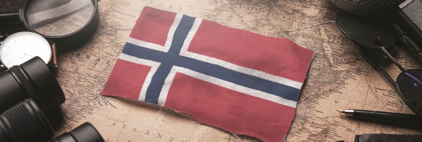 Norway flag between traveler's accessories on old vintage map. tourist destination concept

