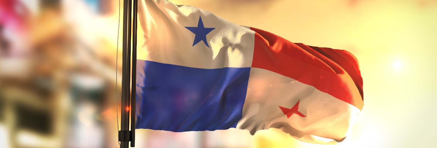 Panama flag against city blurred background at sunrise backlight
