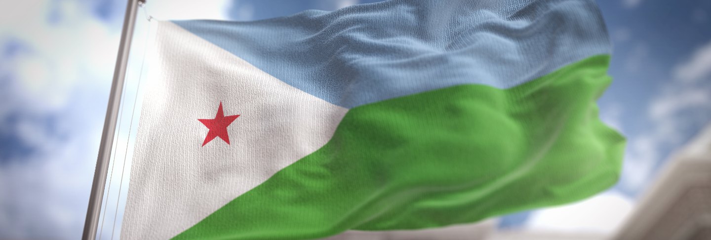 Djibouti flag against city blurred background at sunrise
