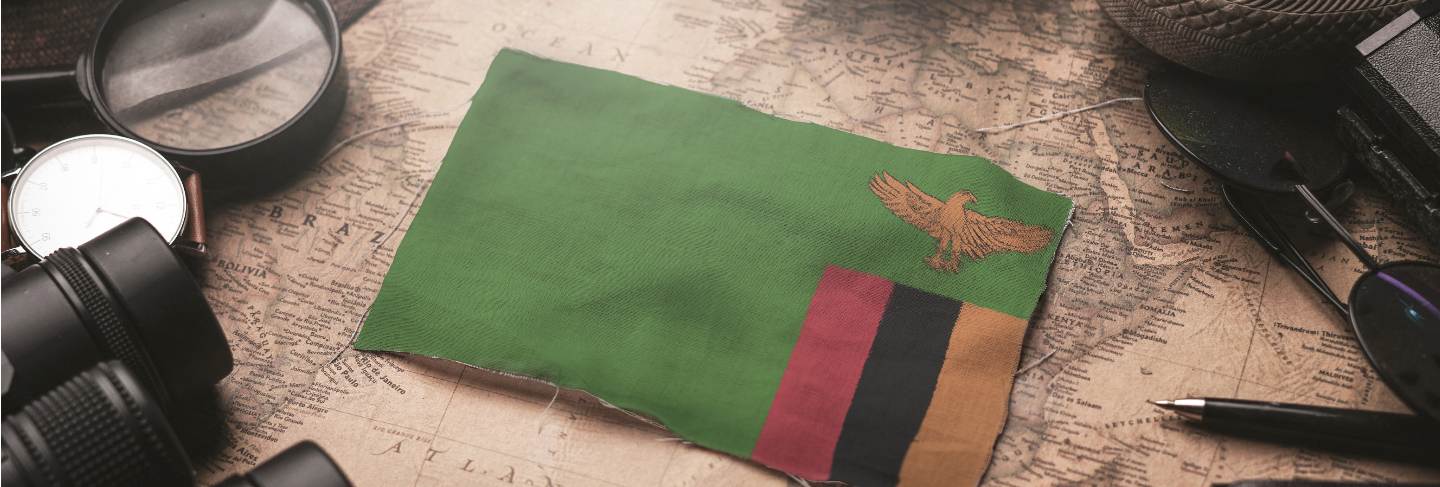 Zambia flag between traveler's accessories on old vintage map. tourist destination concept
