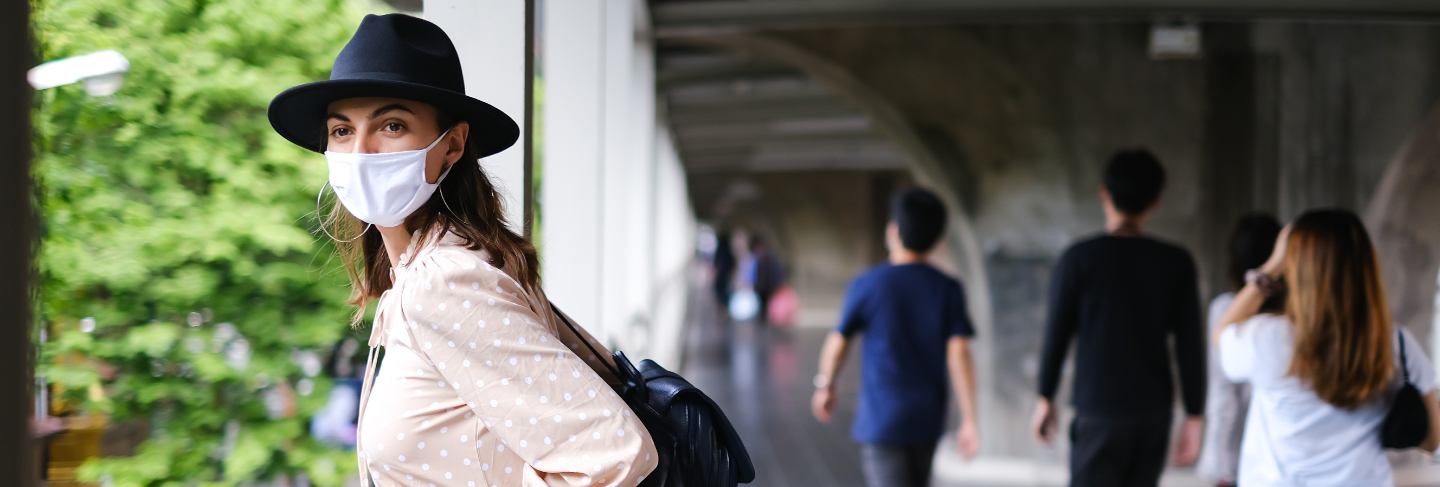 Caucasian woman walking on subway crossing in medical face mask while pandemia in bangkok city.
