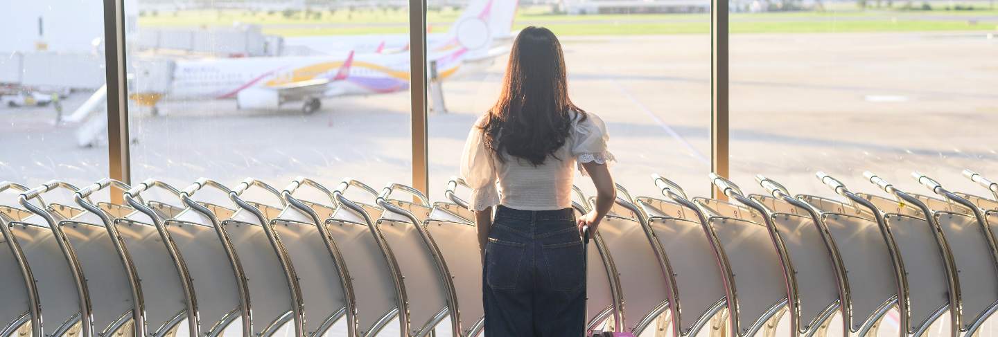 A traveller woman is wearing protective mask in international airport, travel under covid-19 pandemic, safety travels, social distancing protocol
