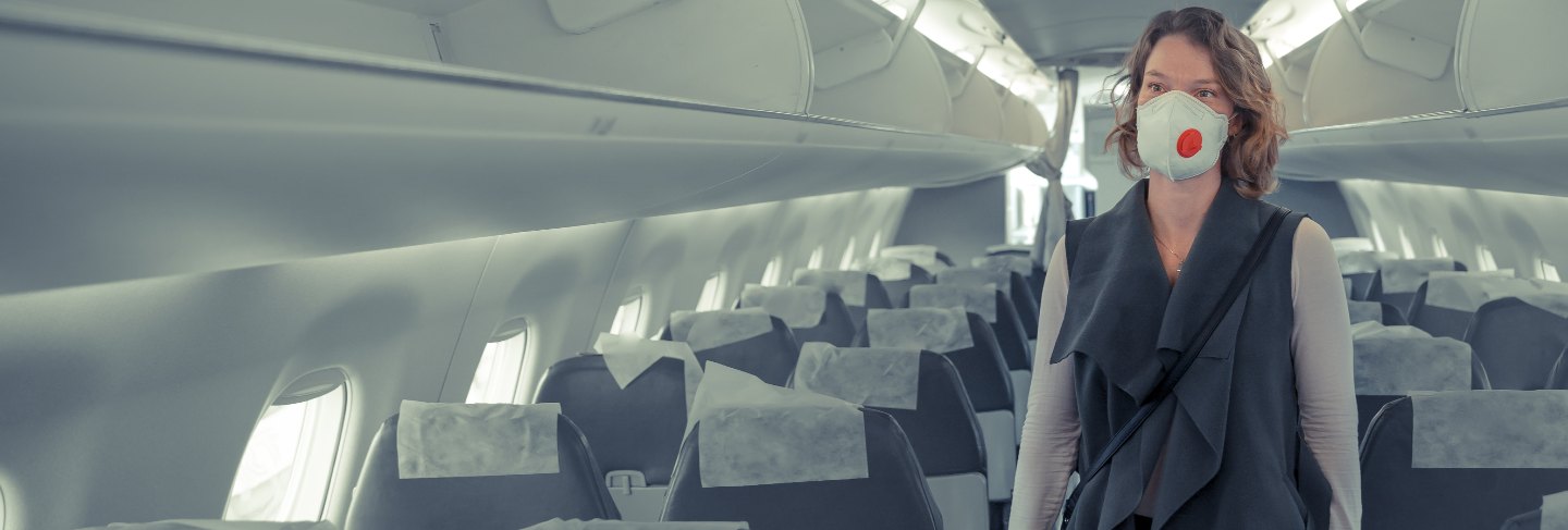 Woman on board of aircraft with respirator on head. protect themselves against viral disease. people cancel travel abroad due to coronavirus
